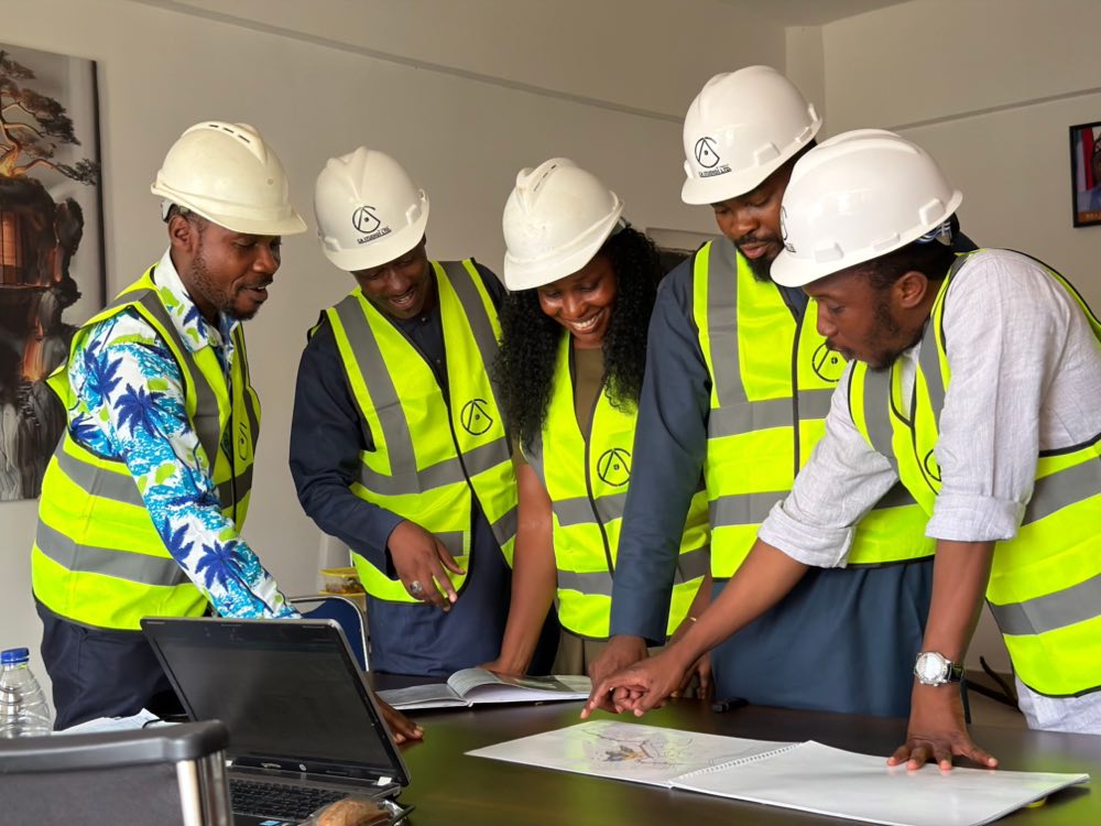 A group of engineers in safety gear reviewing plans together