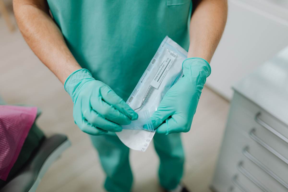 A professional opening a sterile instrument packet