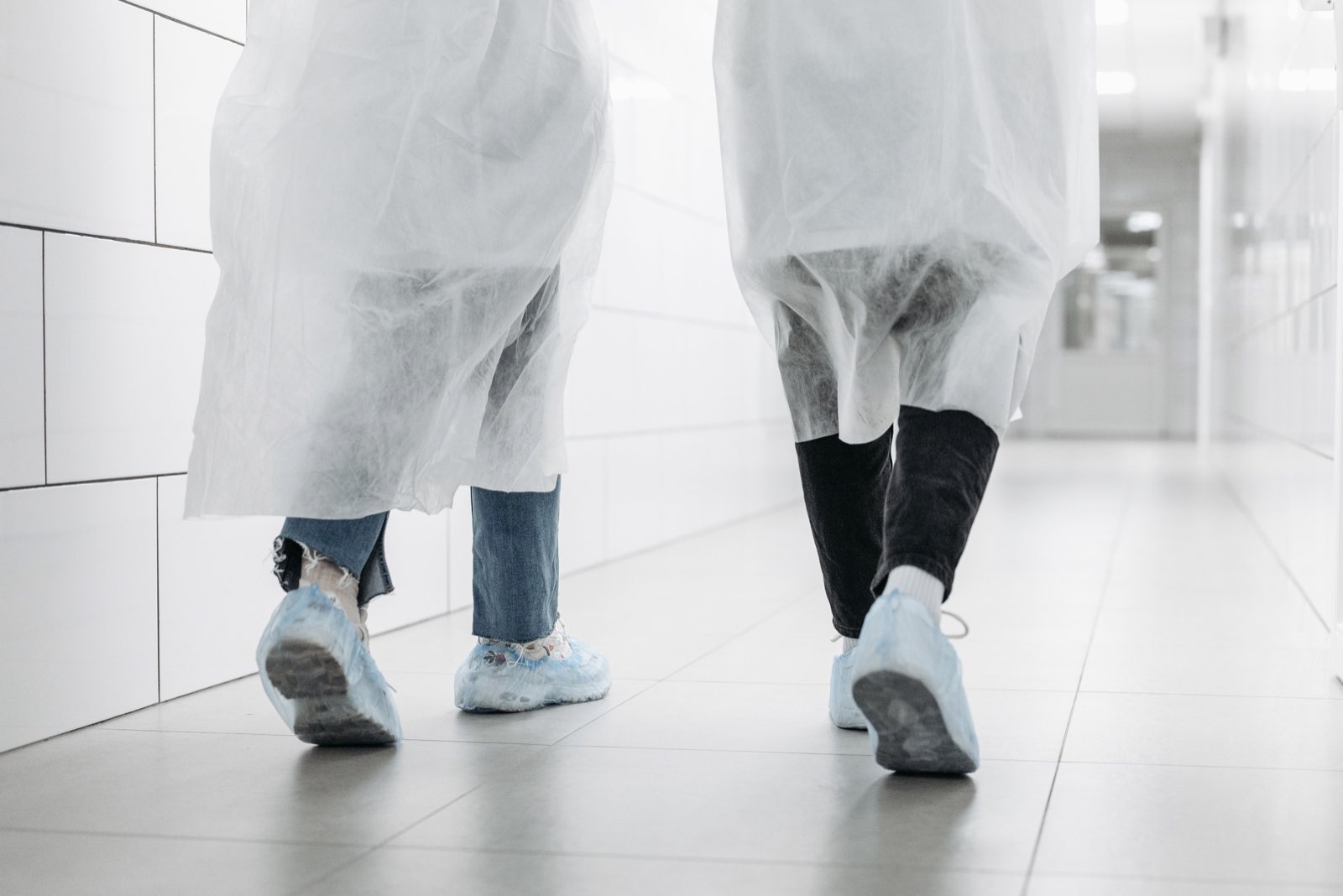 Gowned operators moving through a controlled sterile-manufacturing corridor
