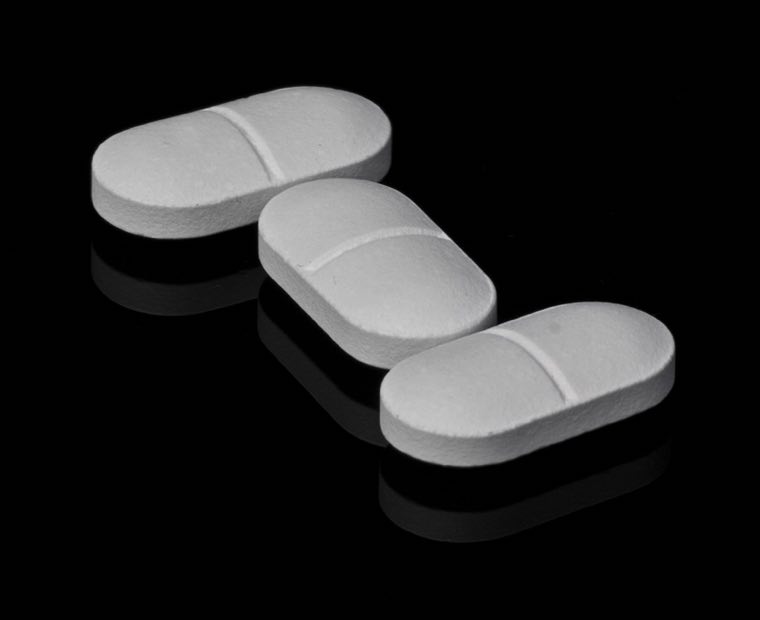 Pharmaceutical tablets on a dark reflective surface