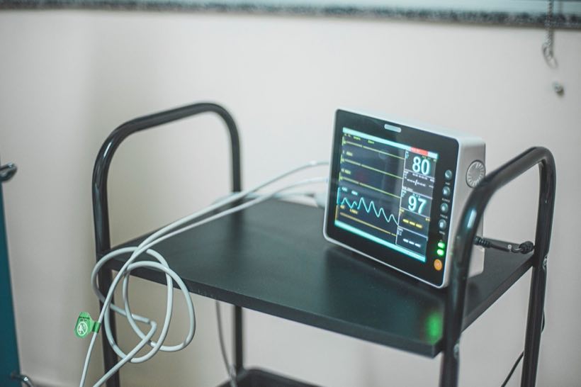 Cardiac monitor displaying vitals on a clinical cart