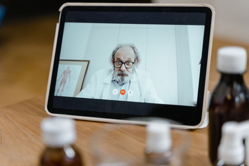 Telemedicine consultation on a tablet propped at a bedside