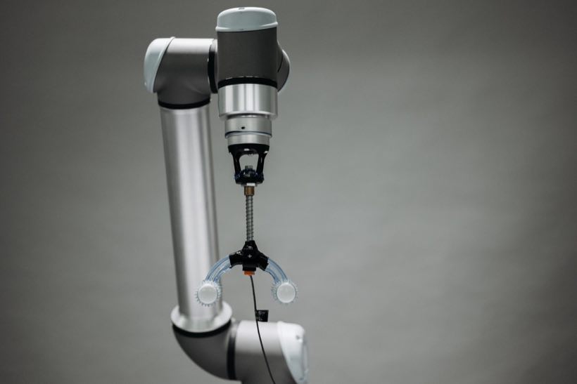 Surgical robotic arm poised in an operating suite