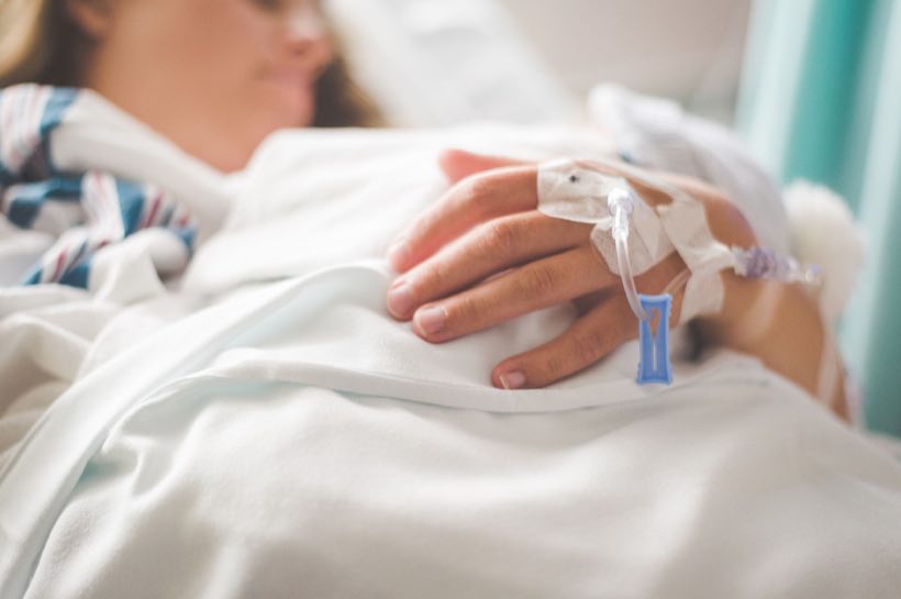 Focused shot of a patient's hand with IV in a hospital setting