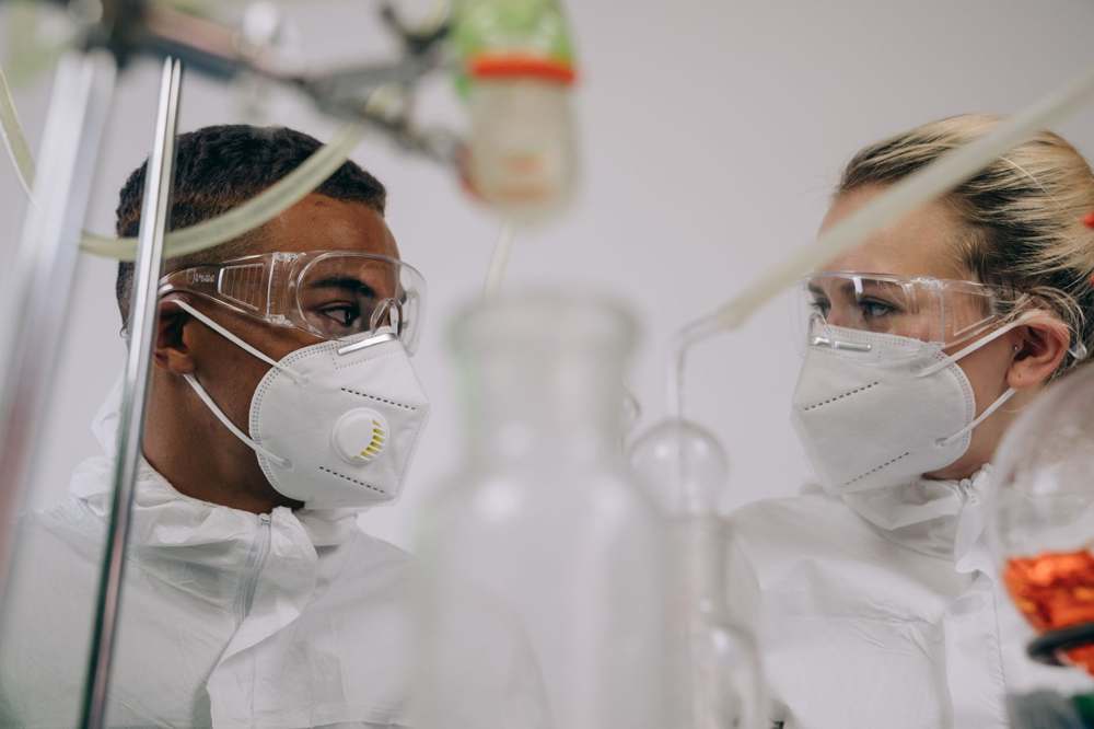 Researchers in protective equipment working together in a laboratory