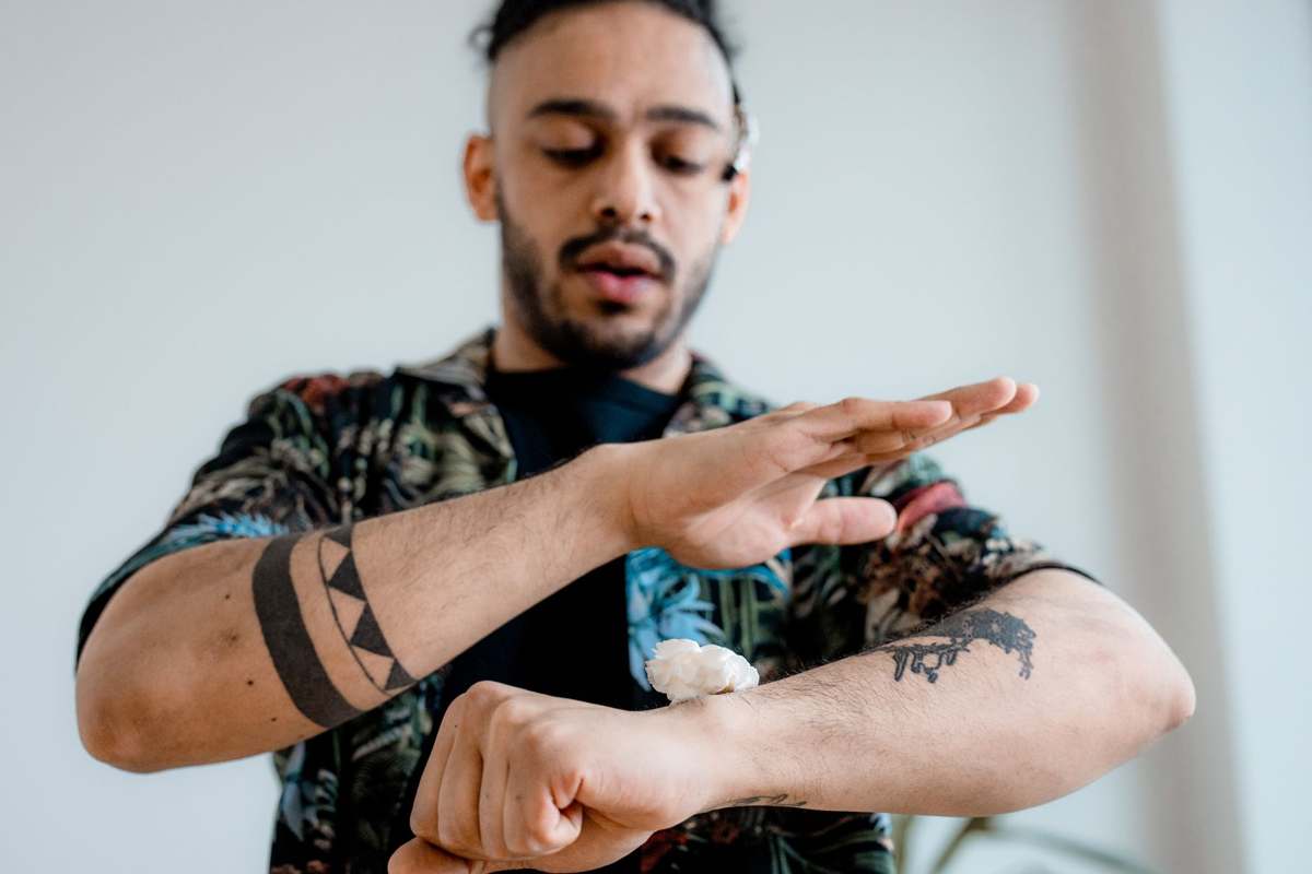 A person applying cream to their forearm