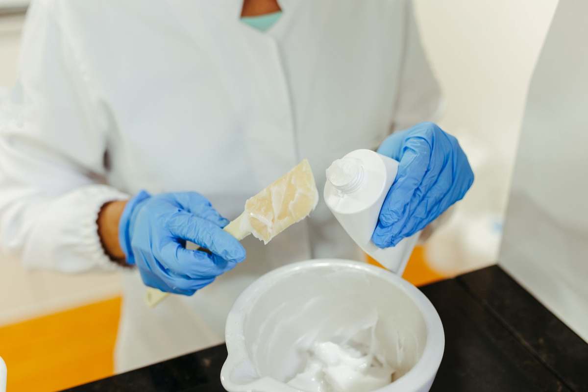 A scientist compounding a cream formulation in a laboratory