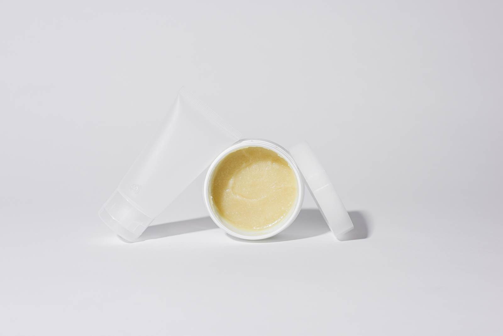 White containers with cream product in a studio setting