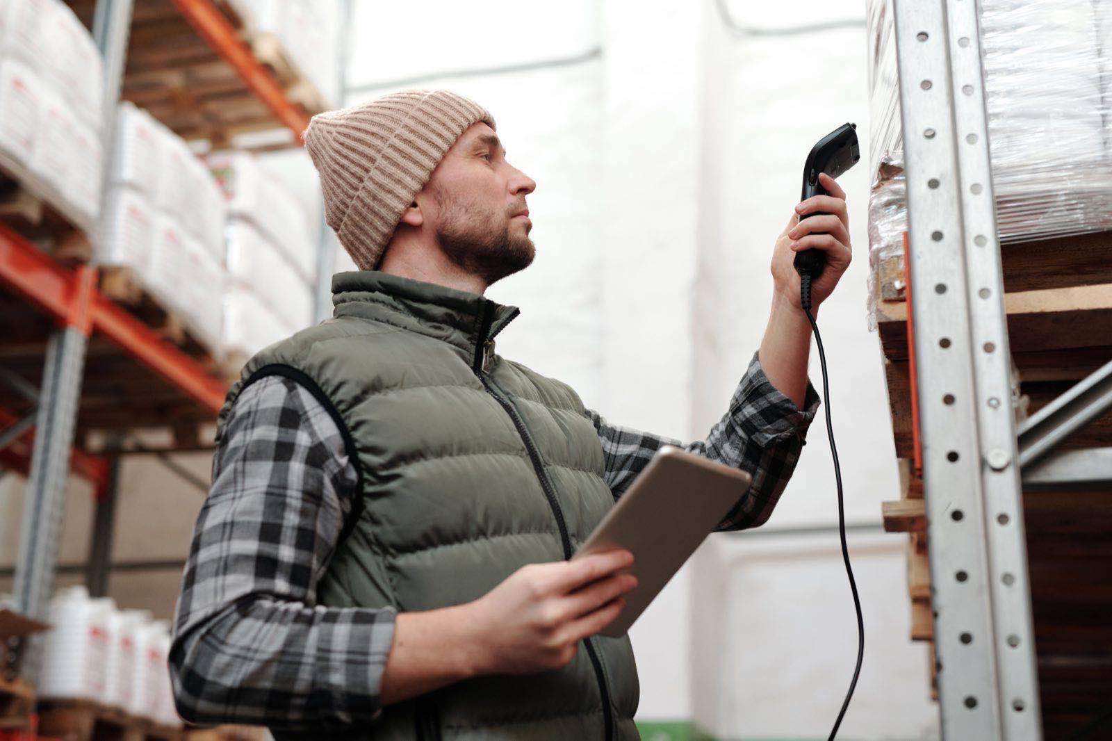 A warehouse professional scanning a package barcode with a handheld scanner