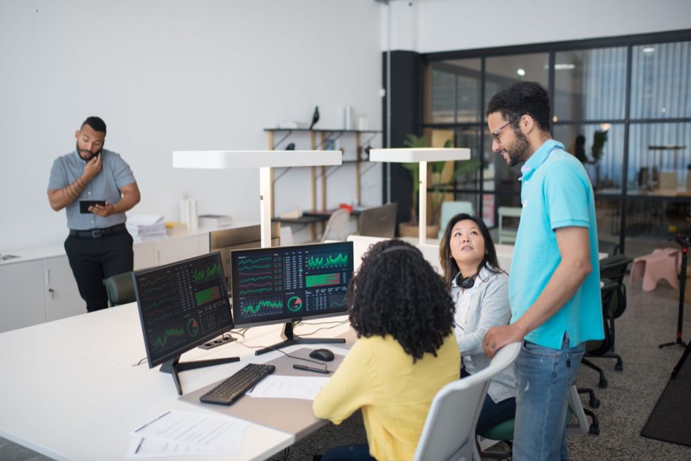 A data quality team reviewing records together at a workstation