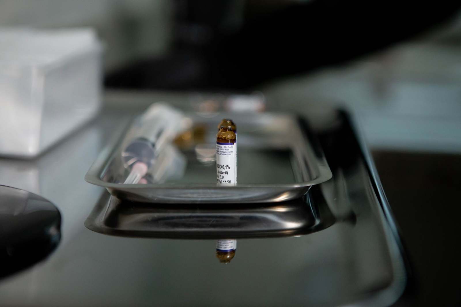 A vial resting on a stainless steel laboratory tray