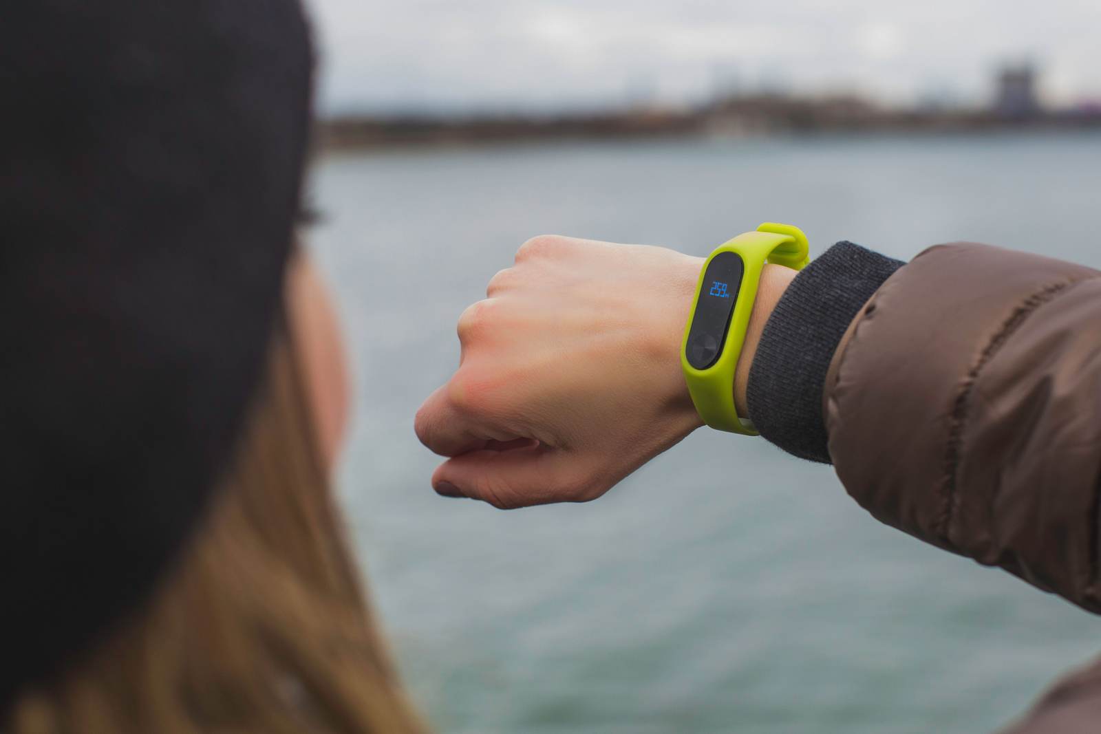 A person outdoors checking a smartwatch on their wrist